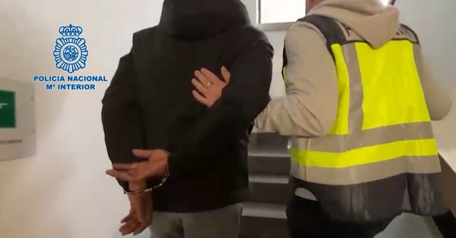 Uno de los detenidos, en dependencias policiales de Palma, junto a un agente.