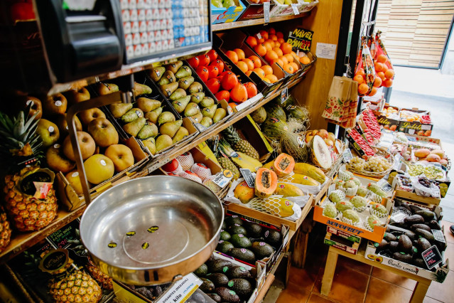 Archivo - Una balanza y varias piezas de frutas y hortalizas en la frutería 'Vitaminas' en Madrid (España).