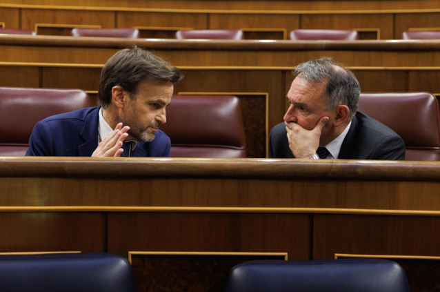 El presidente del grupo confederal y dirigente de En Comú Podem, Jaume Asen (i), y el secretario general del PCE y portavoz parlamentario de Izquierda Unida, Enrique Santiago (d),  conversan durante una sesión plenaria en el Congreso de los Diputados, a 7