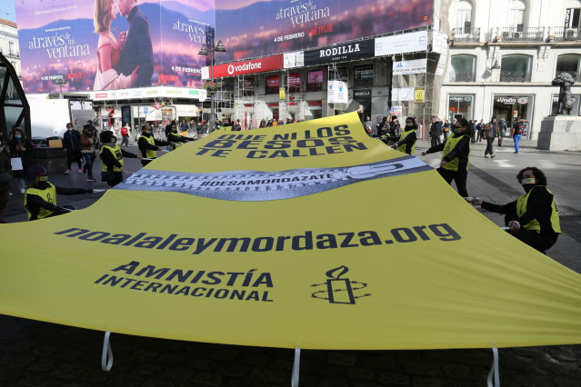 Archivo - Un grupo de personas colocan una lona contra la Ley Mordaza con el lema 