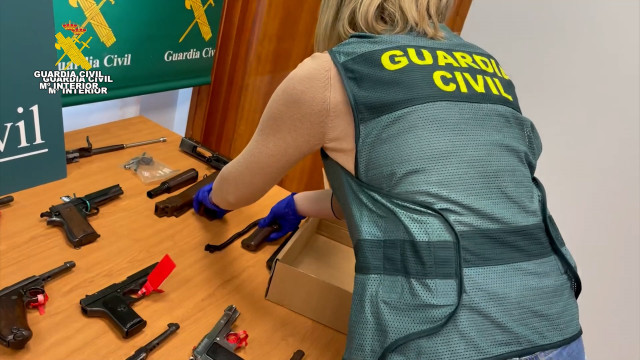 Una agente de la Guardia Civil con algunas de las armas intervenidas en la operación.