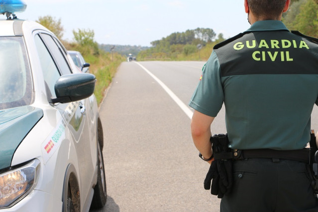 Un agente de la Guardia Civil junto a un coche.