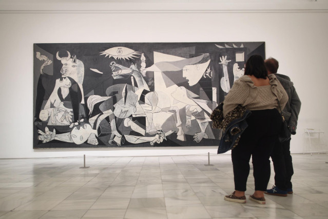 Archivo - Dos personas observan el 'Guernica' de Pablo Picasso en una de las salas del Museo Reina Sofía un día antes del término del estado de alarma, en Madrid (España), a 23 de octubre de 2020.