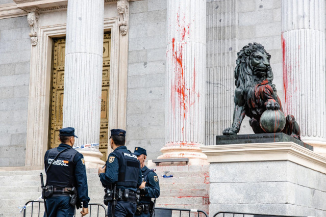 Tres agentes de Policía Nacional delante de las escalinatas del Congreso de los Diputados que han sido teñidas con pintura roja por activistas de Futuro Vegetal y Rebelión Científica, a 30 de marzo de 2023, en Madrid (España).
