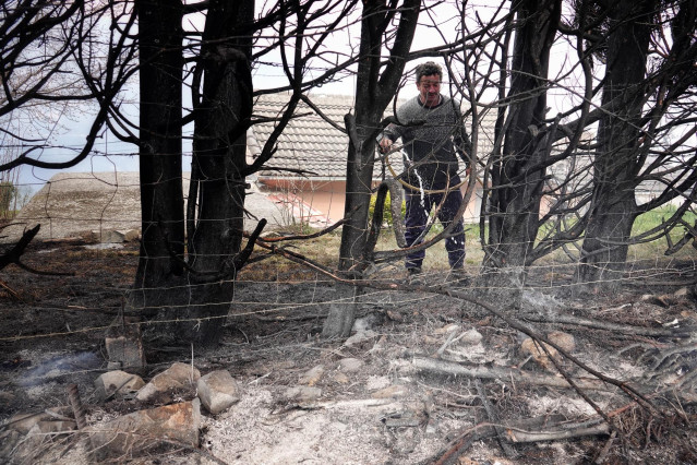 Un hombre retira las ramas quemadas en el incendio de los concejos de Valdes y Tineo, a 30 de marzo de 2023, en Asturias (España).