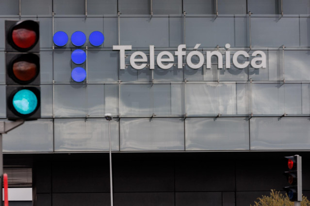 Un semáforo en verde frente a la fachada de la sede de Telefónica, a 6 de marzo de 2023, en Madrid (España).