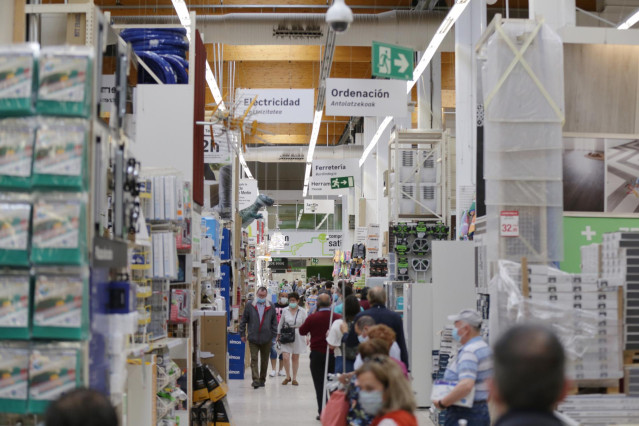 Archivo - Varias personas compran en el interior de una tienda