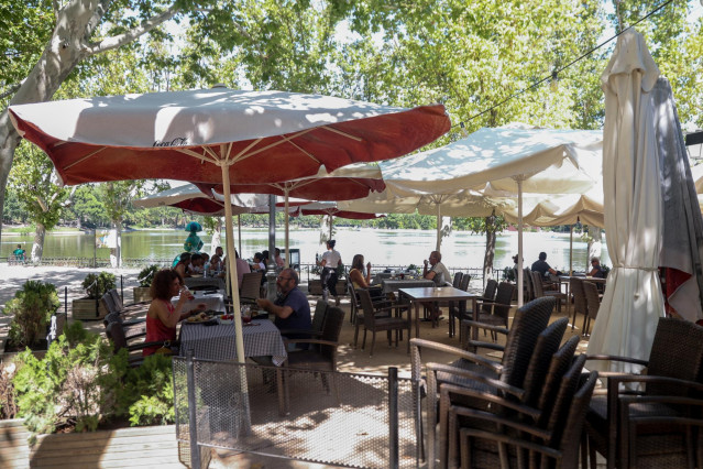 Archivo - Varias personas disfrutan de la hostelería en las terrazas de las inmediaciones del lago de la Casa de Campo, en Madrid (España).
