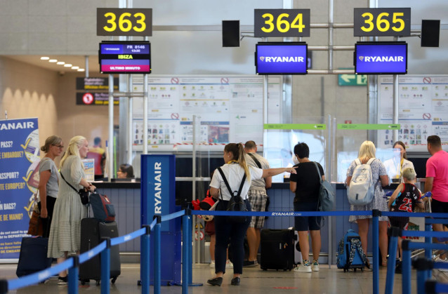 Archivo - Cientos de turistas hacen colas en los puestos de embarque de Ryanair, en el Aeropuerto Costa del Sol, en Málaga, Andalucía.