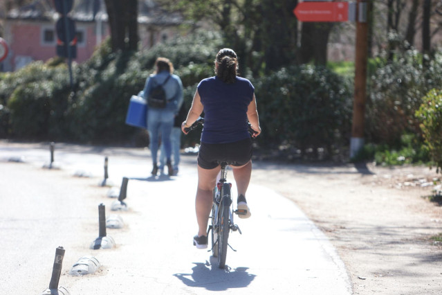 Una mujer montando en bicicleta en la Casa de Campo, a 19 de marzo de 2023, en Madrid (España).
