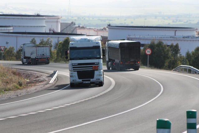 Archivo - Varios camiones circulando por una carretera