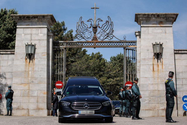 El coche fúnebre con los restos de José Antonio Primo de Rivera sale de la basílica del Valle de Cuelgamuros con destino al cementerio de San Isidro