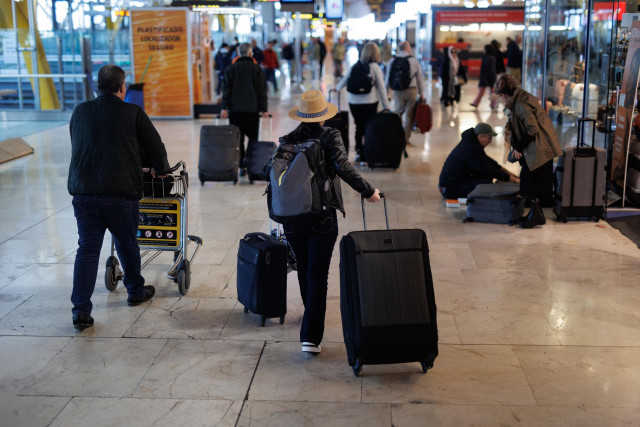 Varias personas con maletas en la terminal T4 del aeropuerto de Adolfo Suárez-Madrid Barajas, a 5 de abril de 2023, en Madrid (España).
