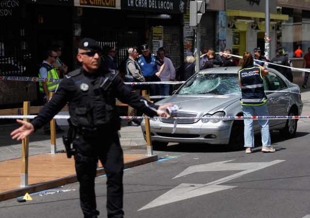 Una agente de la policía nacional toma fotografías del coche con el que han sido atropelladas varias personas, en el Paseo de Extremadura, en Madrid