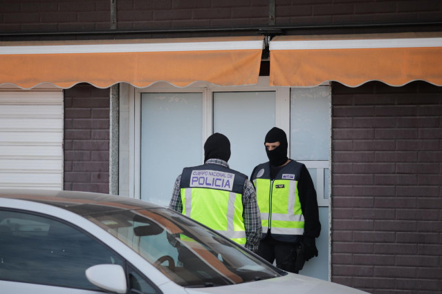 Dos agentes de la Policía Nacional en la puerta de un domicilio, 23 de mayo de 2023, en Melilla (España).