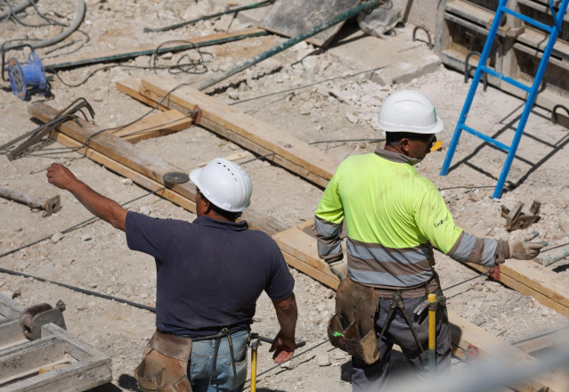 Archivo - Dos obreros durante la construcci&oacute;n de una obra.