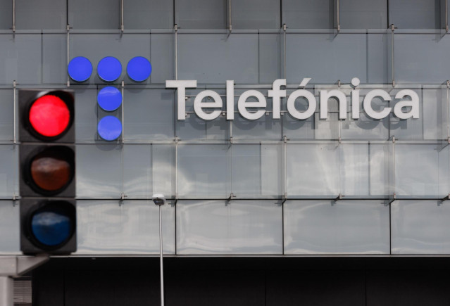 Archivo - Un sem&aacute;foro en rojo frente a la fachada de la sede de Telef&oacute;nica, en Madrid (Espa&ntilde;a).