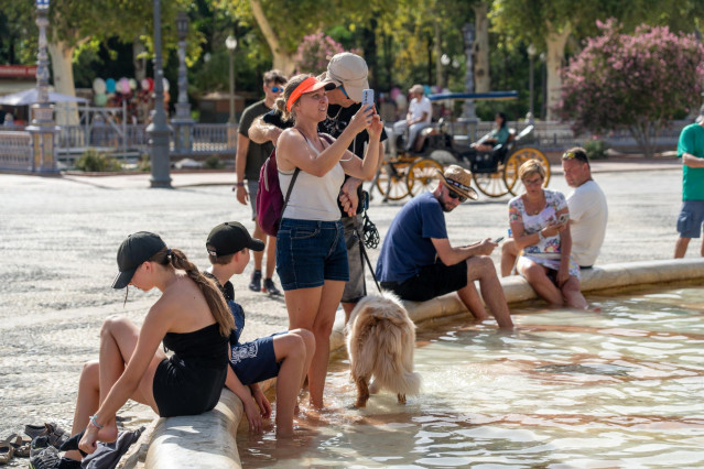 Turistas se refrescan en la fuente de la Plaza de Espa&ntilde;a, en plena ola de calor a 07 de agosto del 2023 en Sevilla (Andaluc&iacute;a, Espa&ntilde;a).