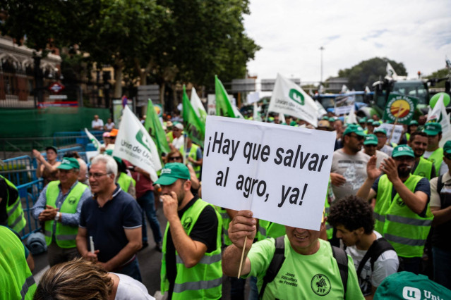 Archivo - Un hombre con un cartel en el que se lee: '&iexcl;Hay que salvar al agro ya!' durante una tractorada frente al Ministerio de Agricultura.