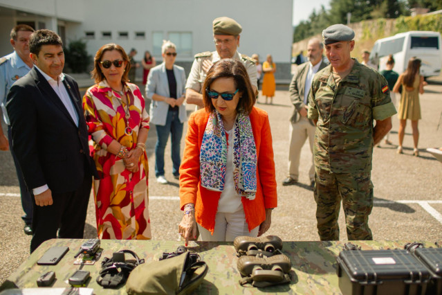 La ministra de Defensa en funciones, Margarita Robles (2d), observa algunos prism&aacute;ticos situados encima de una mesa durante su visita a los componentes de la Brigada 'Galicia' VII Brilat en su Base 'General Morillo', a 21 de agosto de 2023, en Vilaboa, Po