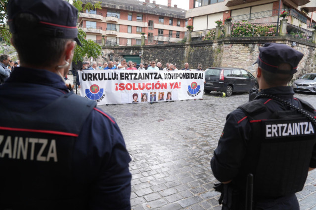 Varias personas sostienen una pancarta que reza: 'Urkullu: Ertzaintza, konponbidea ¡Solución ya!' frente al Palacio de Miramar, a 29 de agosto de 2023, en Donostia-San Sebastián