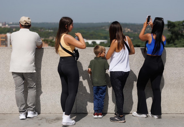 Archivo - Turistas toman fotografías frente al Palacio Real de Madrid, a 17 de julio de 2023, en Madrid (España).