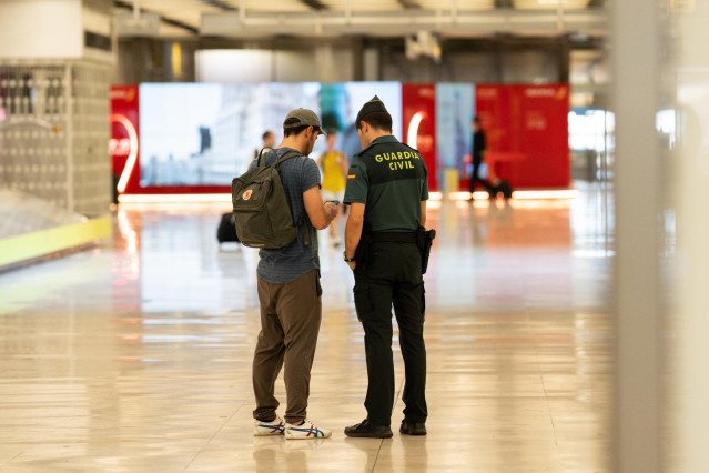 Un pasajero habla con una agente de la Guardia Civil en la T4 el Aeropuerto Adolfo Suárez Madrid-Barajas, a 9 de septiembre de 2023, en Madrid (España).