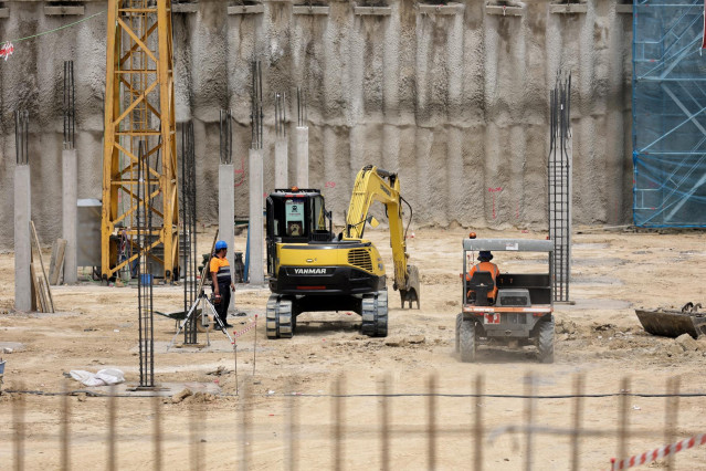 Archivo - Varios operarios de la construcción trabajando en una obra en Madrid