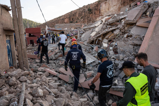 Varios bomberos de la ONG BUSF caminan por una zona destruida por el terremoto, a 12 de septiembre de 2023, en Imi N’Tala (Marruecos). (Foto de archivo).