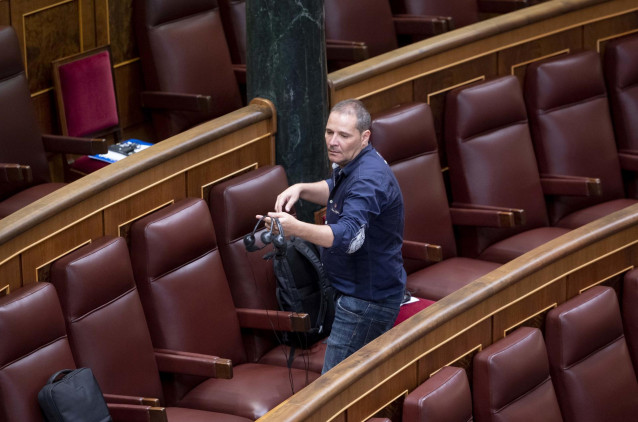 Preparativos del debate de investidura, con un funcionario d ela Cñamara repartiendo los pinganillos para que los diputados puedan recibir la traducción simultánea de las lenguas cooficiales