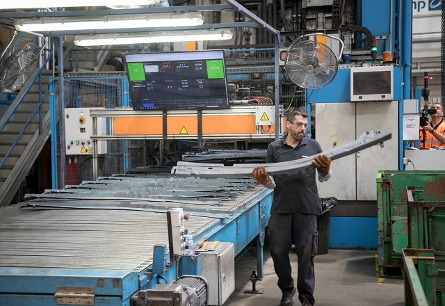 Archivo - Trabajador en fábrica de componentes vehículos (industria)