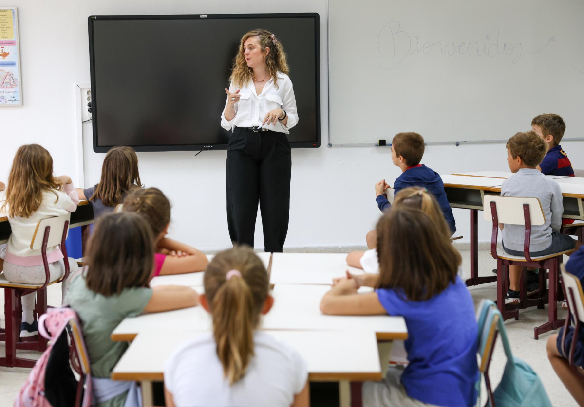 Archivo - Una profesora habla con sus alumnos en un colegio de Madrid
