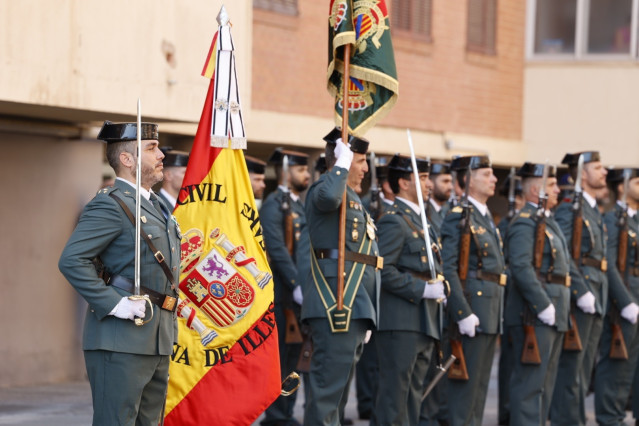 Agentes de la Guardia Civil, con una bandera de España, en los actos por la Patrona 2023