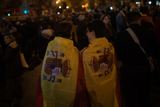 Dos mujeres con la bandera de España durante una manifestación contra la amnistía frente a la sede del PSOE en Ferraz, a 13 de noviembre de 2023, en Madrid (España).