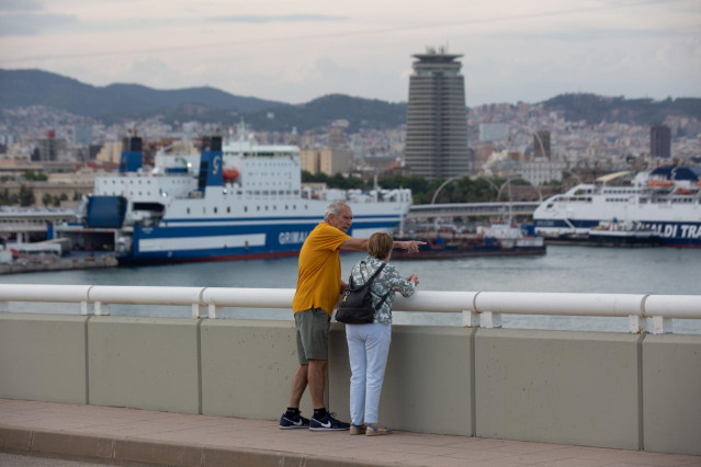 Archivo - Una pareja conversa frente a la terminal de cruceros del Puerto de Barcelona, visto desde el Puente de la Puerta de Europa, a 30 de mayo de 2022, en Barcelona, Cataluña (España).