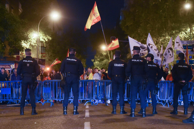 Decenas de manifestantes con banderas y carteles tras las vallas de seguridad y frente a varios agentes de policía, durante una manifestación contra la amnistía frente a la sede del PSOE en Ferraz, a 18 de noviembre de 2023, en Madrid (España).
