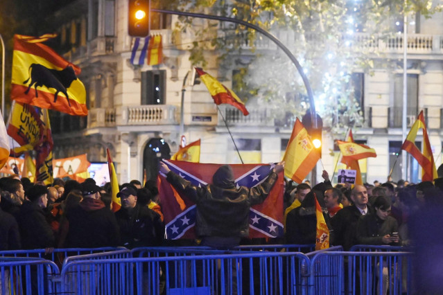 Varias personas portan banderas españolas y una bandera confederada, durante la protesta convocada por el sindicato de Vox, en la calle Ferraz de Madrid, a 24 de noviembre de 2023, en Madrid (España).