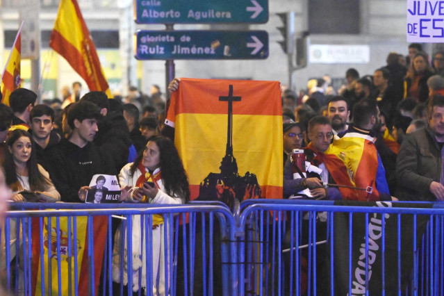 Varias personas portan banderas, durante la protest en la calle Ferraz
