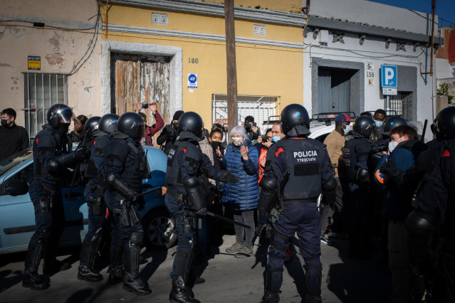 Archivo - Varias personas intentar evitar el desalojo de la policía de una nave industrial okupada que se encuentra en desuso en la calle Progrés de Badalona.