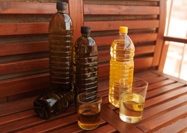 Archivo - Botellas y vasos de aceite de oliva y de girasol