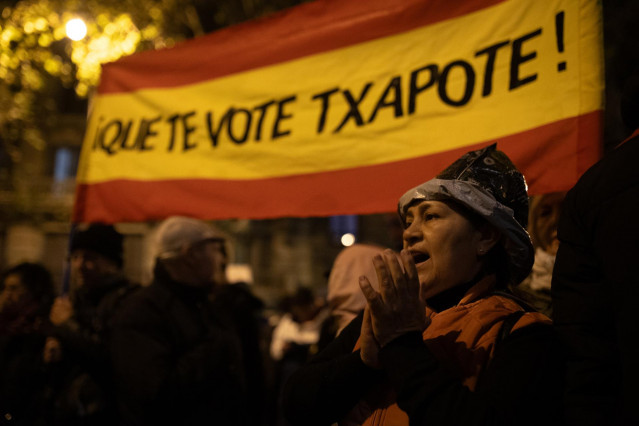 Una manifestante con la bandera de España y el texto 