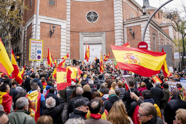 Varias personas con banderas de España durante una concentración frente a las sede del PSOE de la calle Ferraz, a 6 de diciembre de 2023, en Madrid (España).