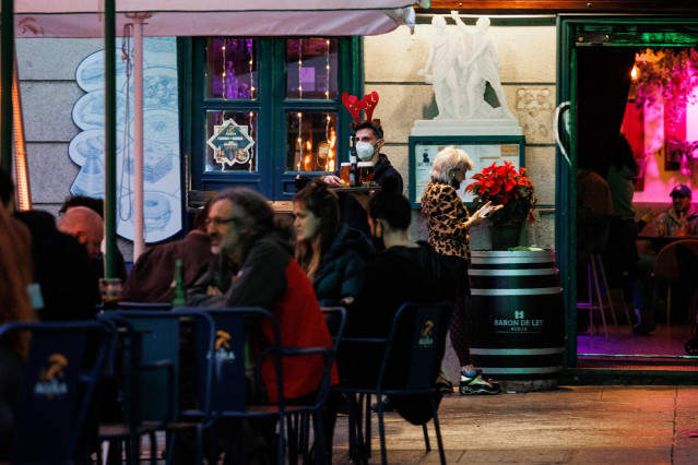 Archivo - Tres amigos toman el aperitivo en la plaza del 2 de mayo para celebrar la llegada de la Nochebuena