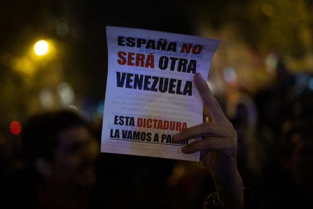 Archivo - Detalle de un cartel 'España no será otra Venezuela', durante la concentración en contra de la amnistía, en la sede del PSOE en la calle Ferraz