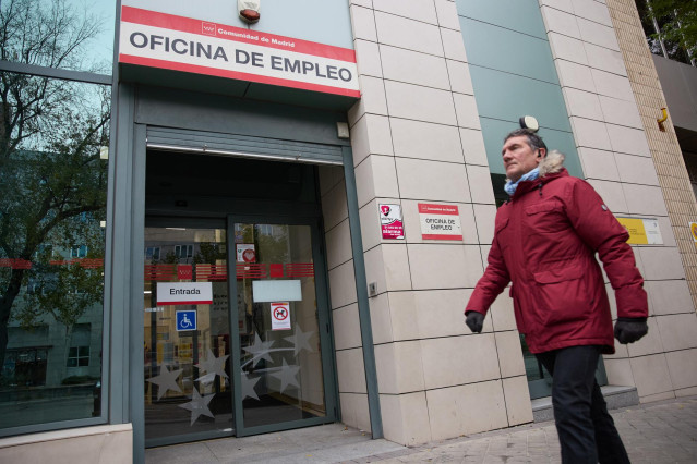 Una persona camina frente a la entrada de la oficina de empleo