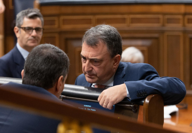 El presidente del Gobierno, Pedro Sánchez (i), conversa con el portavoz del PNV en el Congreso, Aitor Esteban (d), durante un pleno en el Congreso.