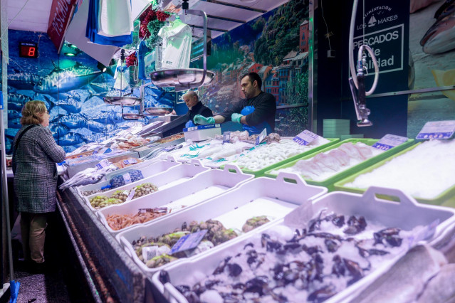 Archivo - Una mujer realiza sus últimas compras de pescado y marisco en la tienda de comestibles ‘Los Mares Alimentación’, en el barrio de Prosperidad, a 24 de diciembre de 2022, en Madrid (España).