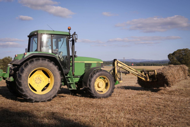 Archivo - Un tractor en el campo