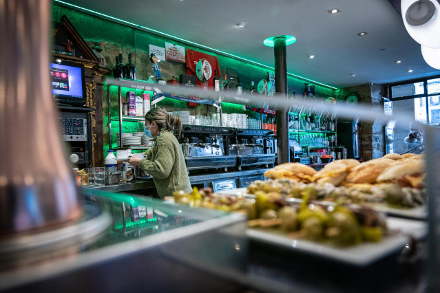 Archivo - Una camarera trabaja en su cafetería durante u