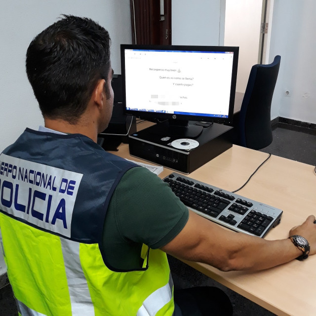 Archivo - Policía Nacional frente a una pantalla de ordenador